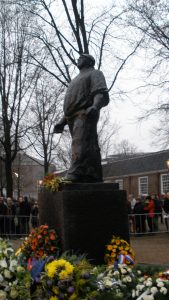 Statue of symbolic figure of the February strike with flowers at his feet