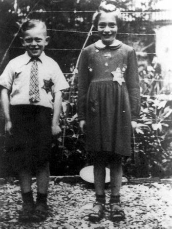 Photo of two children smiling with Stars of David on their clothes
